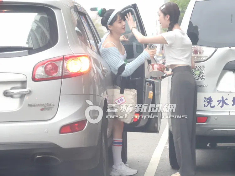 藝人王如茵（右）接手元元的愛心泡麵，熱絡向車內護花使者「三寶男」揮手打招呼。特勤中心攝