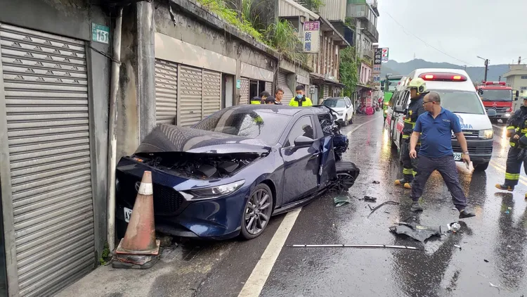 轎車被推擠往前撞上路旁店家鐵捲門、門柱。翻攝畫面