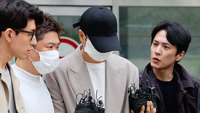 申彗星（中）走出法院後被媒體包圍，面對提問不發一語。韓聯社