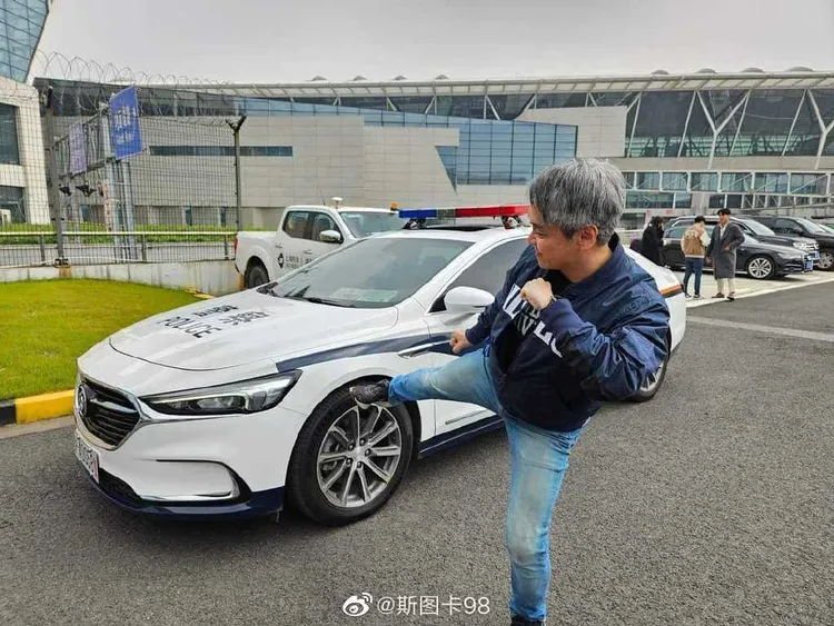 廖元豪作勢踹踢中國公安警車還拍照。翻攝自微博