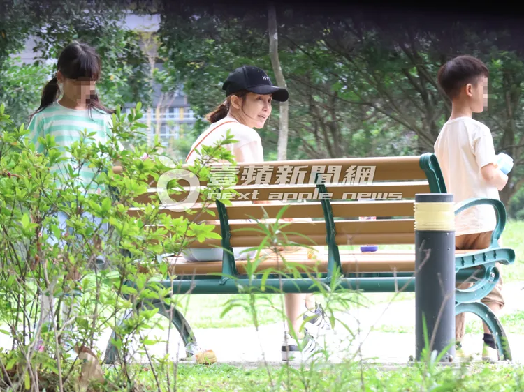 鍾欣怡（中）在公園顧著兩寶，女兒走到椅子後面撿掉在地上的麵包。特勤中心攝