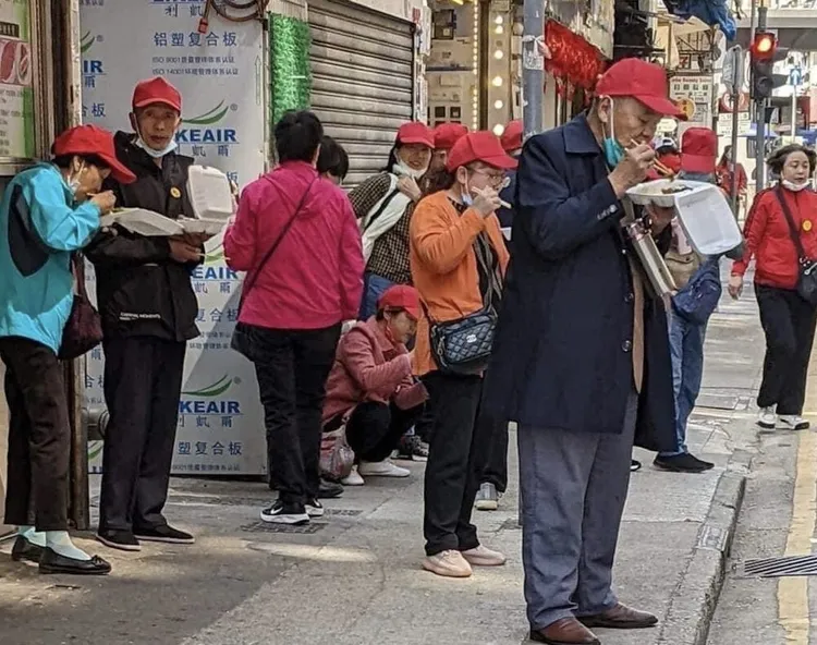 遊客就在街頭食用平價的「兩餸飯」。翻攝香港LIHKG論壇