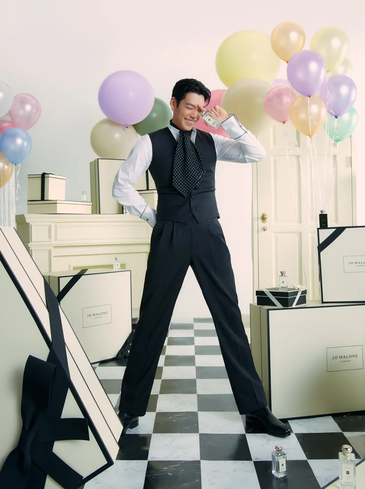 他在佈滿氣球跟禮盒的房間中擺出俏皮姿勢。品牌提供
