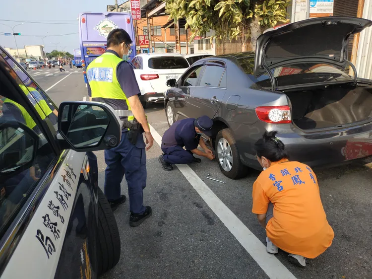 警方協助車輛破胎的信眾更換備胎。民眾提供