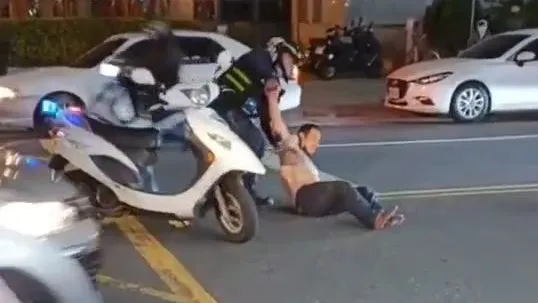 警員奮力將邱男從地上拉起。翻攝自社會事新聞影音