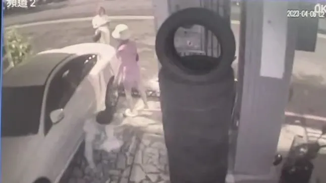 劉男遭砍後痛苦的坐在騎樓。翻攝畫面