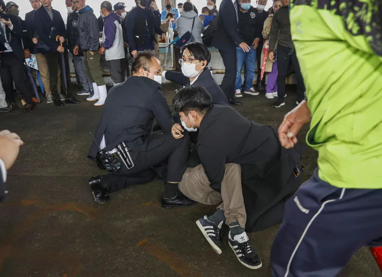 嫌犯被眾人合力壓制在地。美聯社