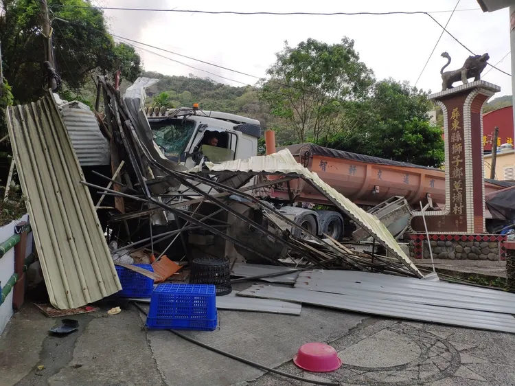 一輛砂石車疑似煞車失靈衝出路外，當場將一部停在路邊的自小客車夾成廢鐵。讀者提供