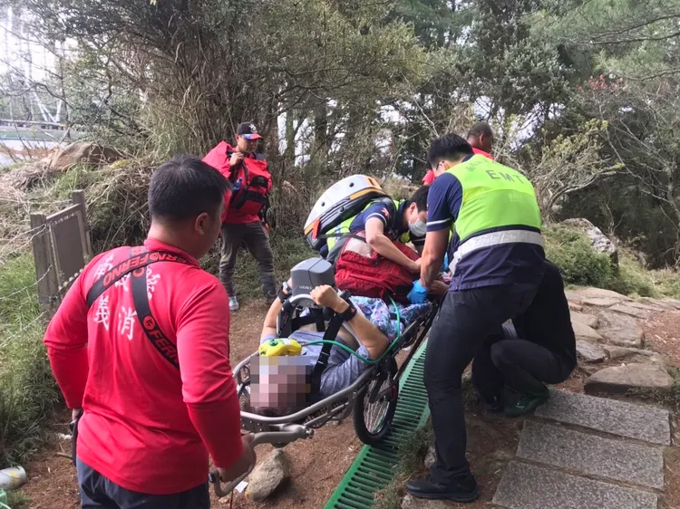 消防人員以人力接駁方式將患者運送下山。民眾提供