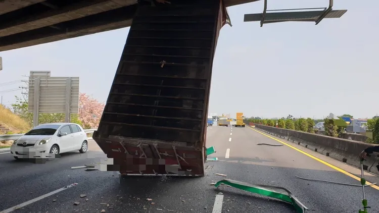 一輛貨櫃車行經國道1號南向303公里麻豆路段，載運貨櫃突然彈起撞橋墩。讀者提供