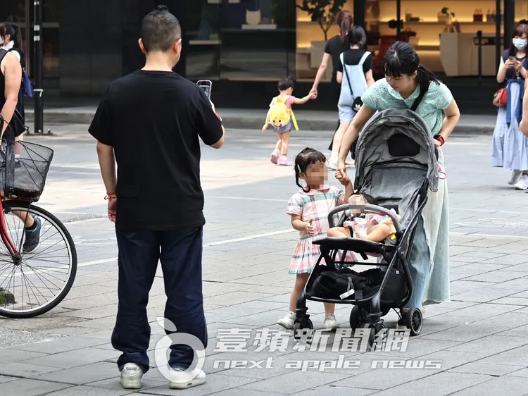 周亭羽（右）一手牽著魯拉拉，一手拉住嬰兒車。特勤中心攝