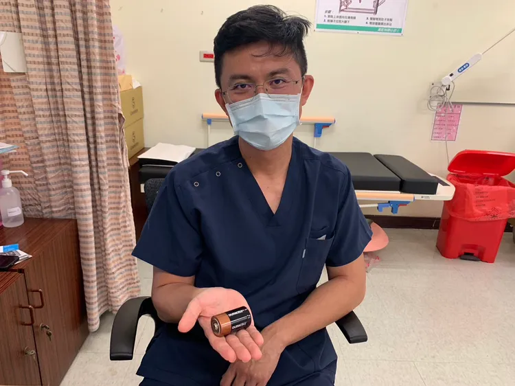 蔡鎧隆醫師手持同款大小電池，非男子體內取出那顆。吳慧芬攝
