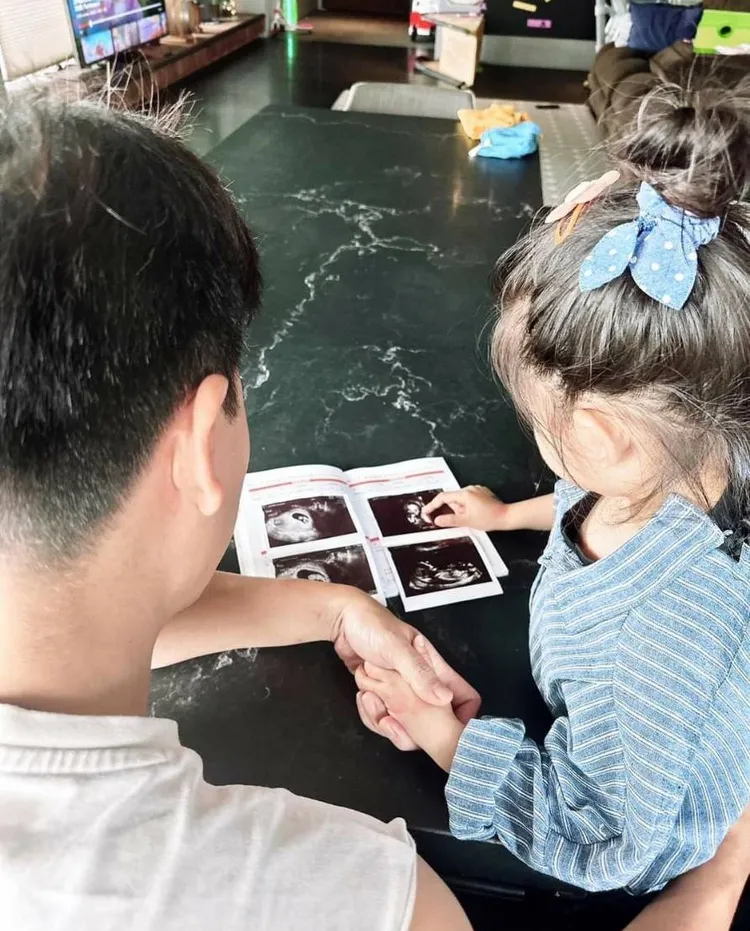 王傳一（左）給大女兒看寶寶的超音波照。翻攝王傳一臉書