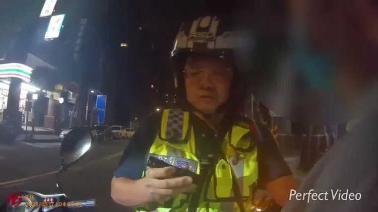 警方拿著鐵盤質問石男。中和警分局提供