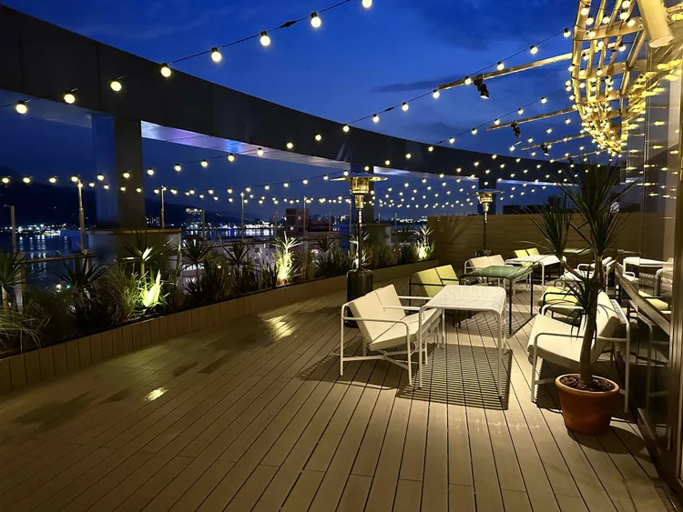 餐廳戶外區能夠從高處遠眺淡水河的絕美景色，白日可以看見對岸八里及觀音山的明媚風光，晚霞時分則有夕陽餘暉與河景相伴。業者提供