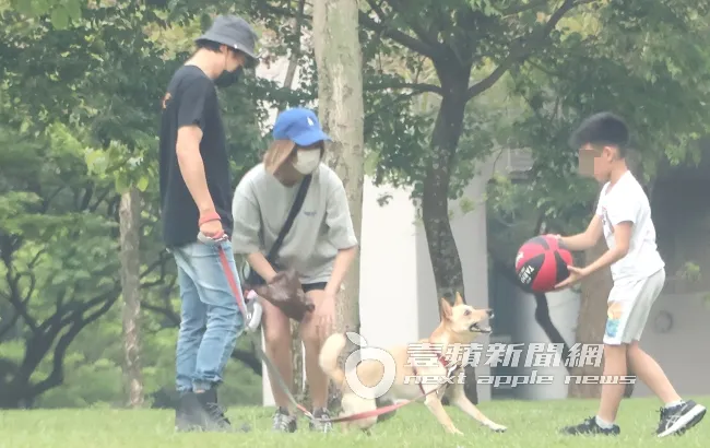 孫協志（左）牽著愛犬，夏宇童起立蹲下跟狗玩籃球。特勤中心攝