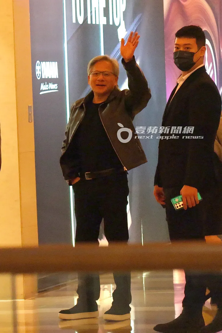 黃仁勳（左）見熱情粉絲，親民揮手打招呼回應，保鑣不敢鬆懈。特勤中心攝