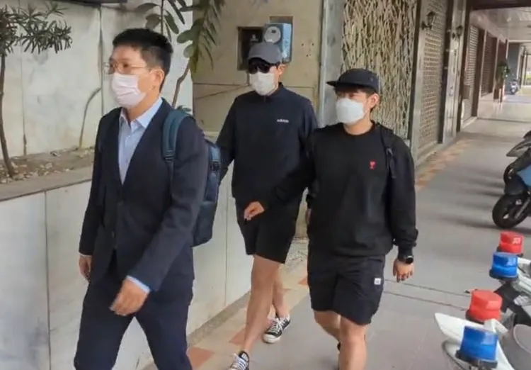 金姓男子（戴墨鏡者）今在律師與哥哥陪同下到派出所報到。讀者提供