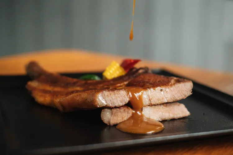 老爺小花園母親節套餐主菜-紐澳良風味戰斧豬排搭紅酒焦糖蘋果。業者提供