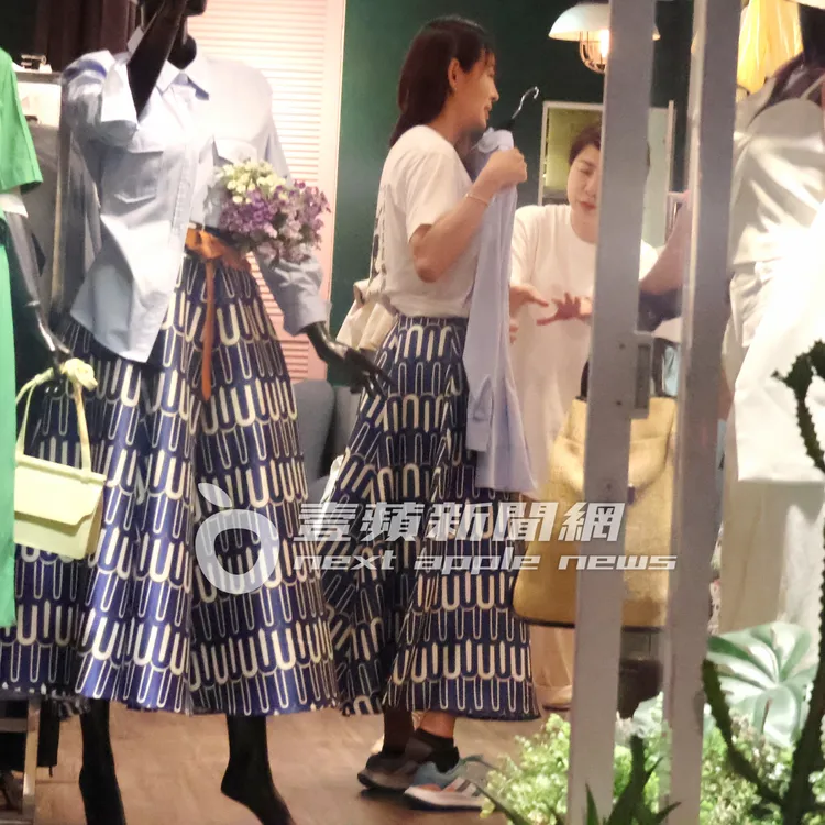 賈永婕接著拿起一件襯衫比對搭配。特勤中心攝