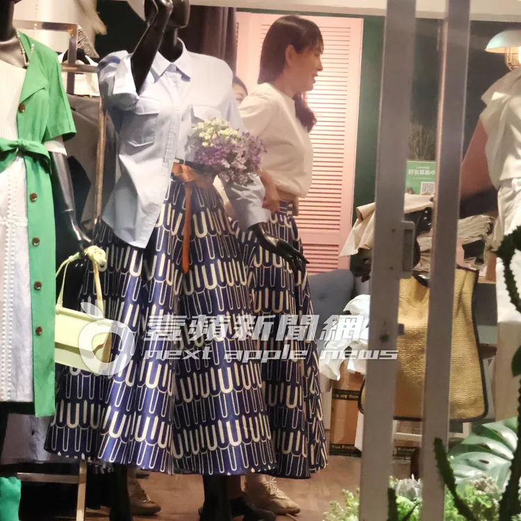 賈永婕站在鏡子前比對試穿裙子看適不適合。特勤中心攝