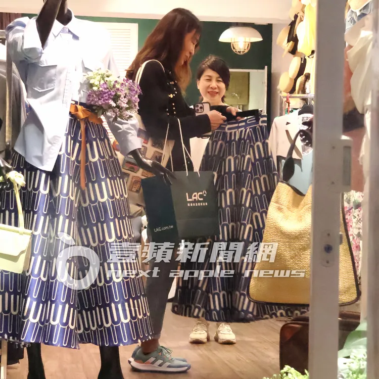 賈永婕（左）馬上看中展示上的裙子，拿起來比對。特勤中心攝