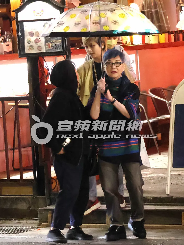 吃完母親節大餐，張小燕（右）撐著傘心滿意足步出餐廳。特勤中心攝