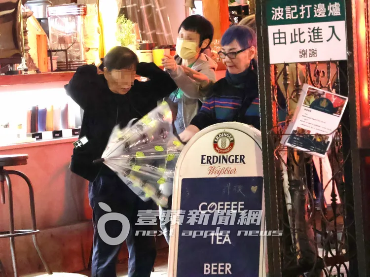 下著毛毛細雨，張小燕（右）走至一旁取傘準備撐傘。特勤中心攝