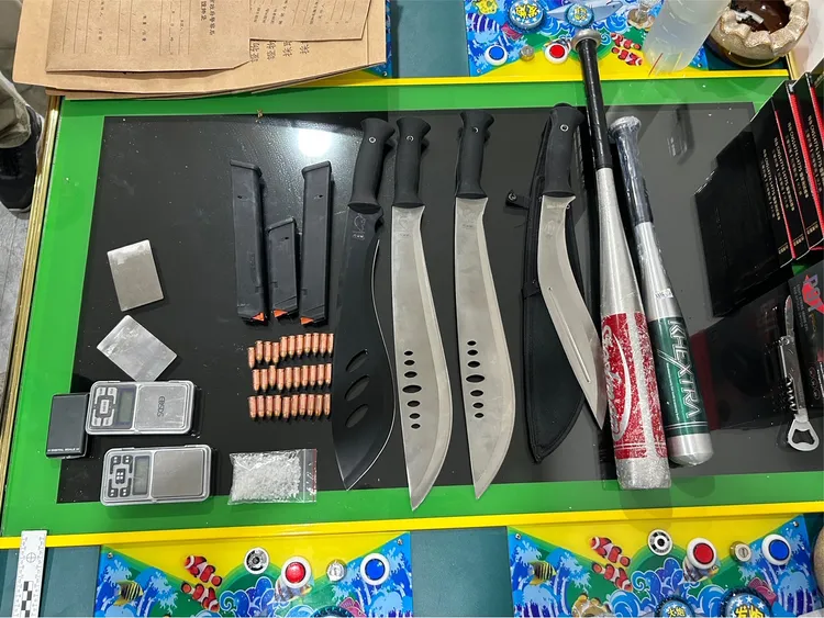 警方在菸酒店內儲物櫃查扣未擊發的子彈31發、開山刀、球棒與K他命毒品等物證。翻攝畫面