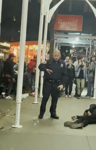 涉嫌重捶街友的美警裴瑞茲似乎打到手痛，檢視拳頭有無受傷。翻攝twitter/Imposter_Edits