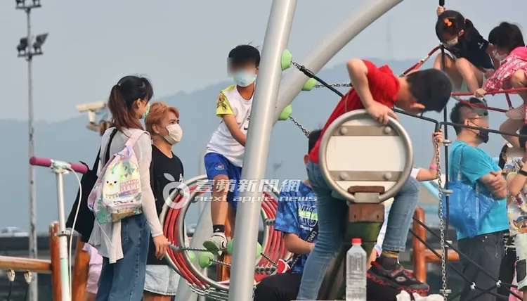 有抓頭髮的歐弟（右二）在人群中成功隱身，看著女兒爬高高，注意小孩安全。特勤中心攝
