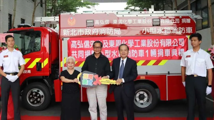 陳姓婦人與東周董事長陳永東捐贈消防車。新北市消防局提供