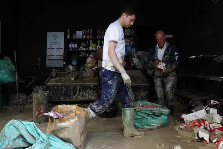 法恩扎鎮居民在水退之後清理家園。路透社