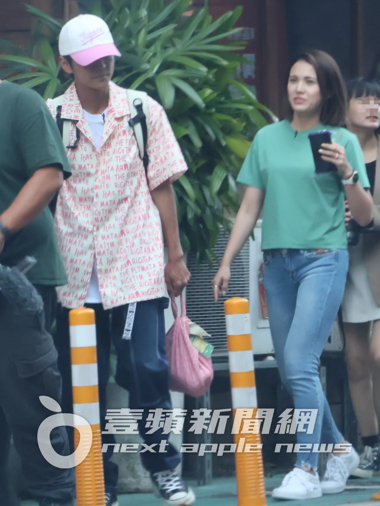 阿翔（左）手提採買的東西，與「混血妹」搭檔潔絲，在街上邊走邊聊天。特勤中心攝