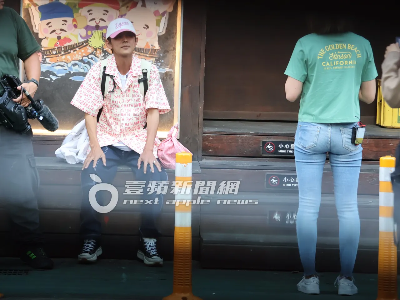 先別管小甜甜謝忻！阿翔（左）坐在路邊休息，眼神直盯著「混血妹」潔絲甜笑，隔空交留。特勤中心攝