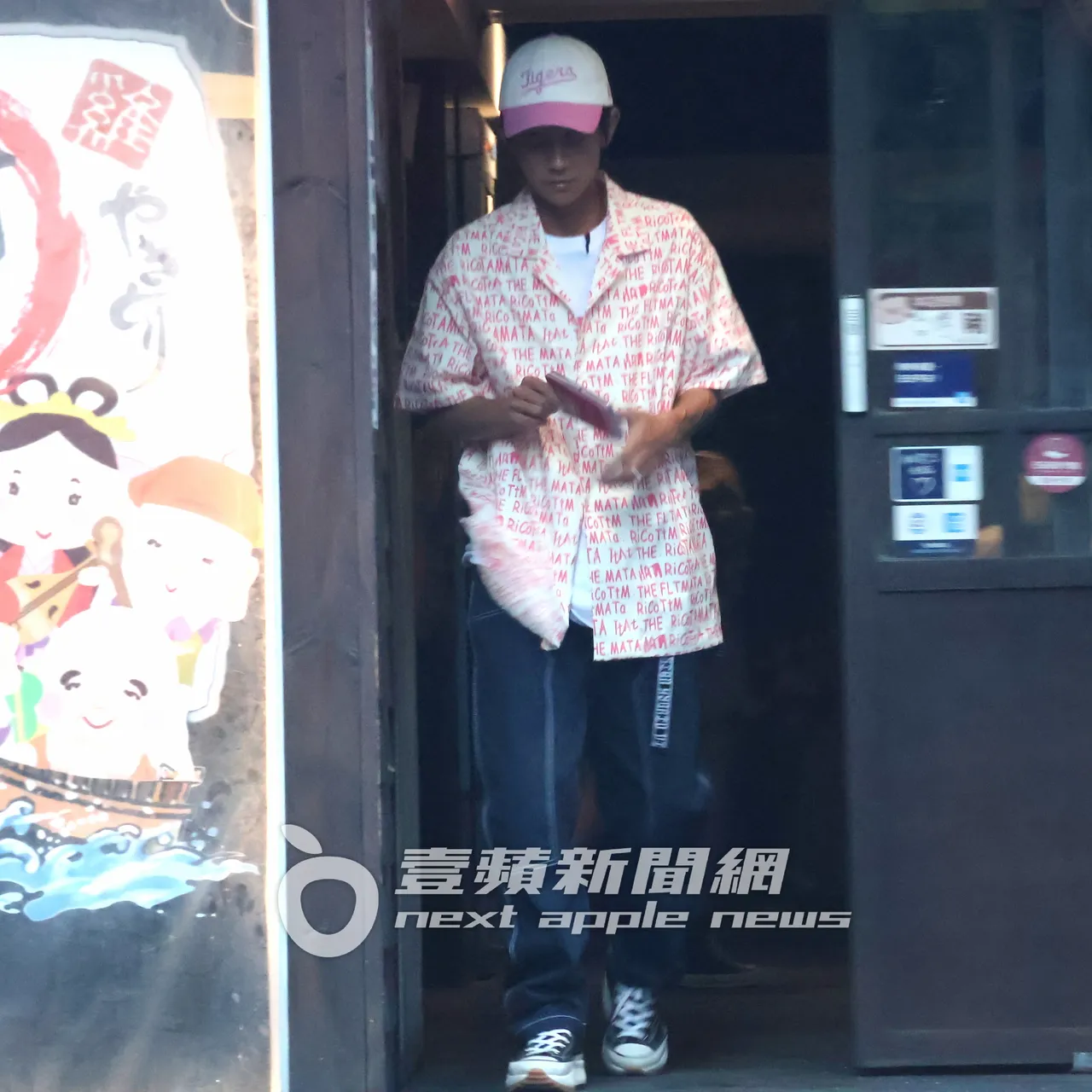 阿翔拿著手機和加熱菸走到餐廳門口準備哈菸。特勤中心攝