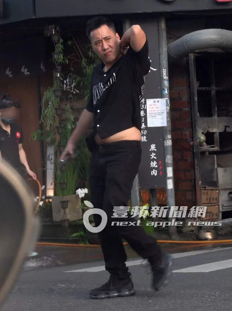 余祥銓舉起手抓癢，露出啤酒肚。特勤中心攝