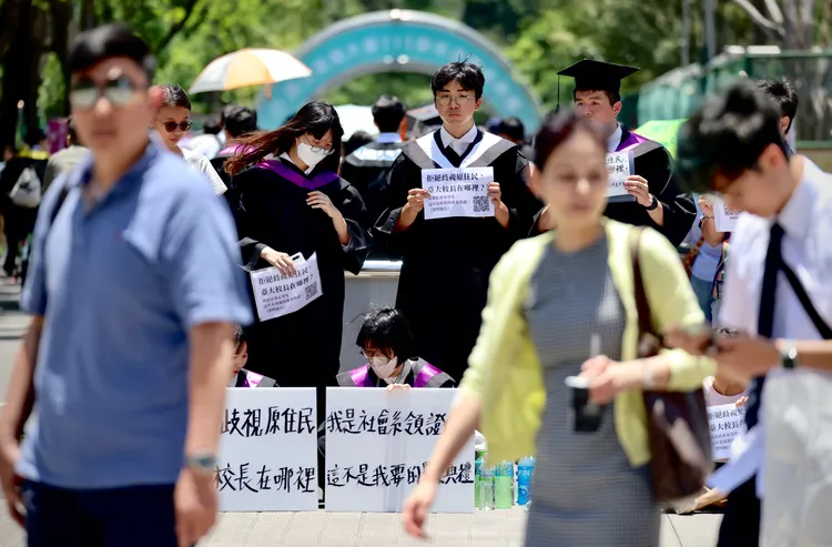 台大今日舉行畢業典禮，有畢業生在會場外舉牌抗議。林林攝