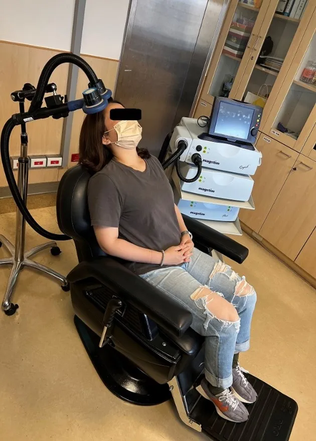 患者接受重複性經顱磁刺激機器治療的情形。中國附醫提供