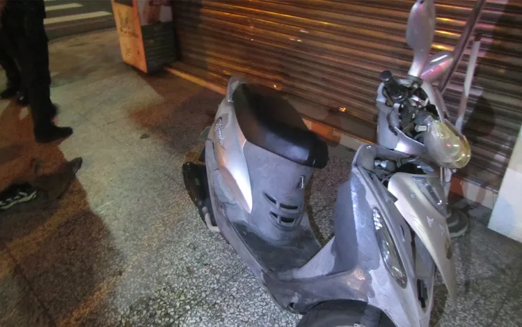 楊男機車車頭破損，店家鐵捲門凹陷。讀者提供