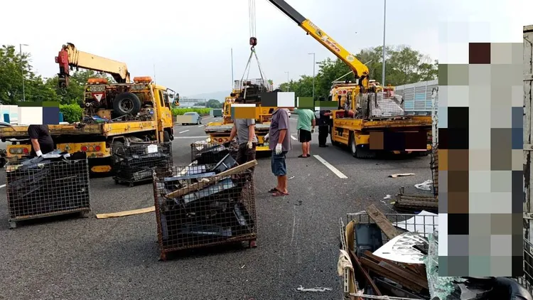 小貨車側翻後，載運的回收鐵製品散落占據道路。讀者提供