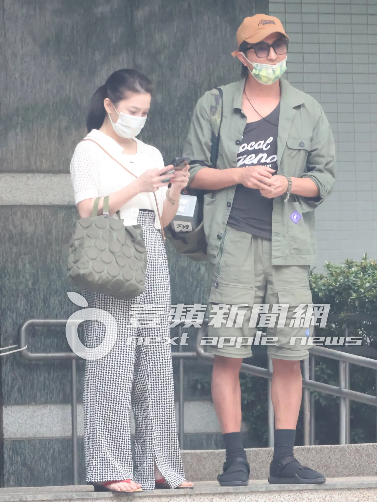許藍方(左)看手機叫計程車。特勤中心攝
