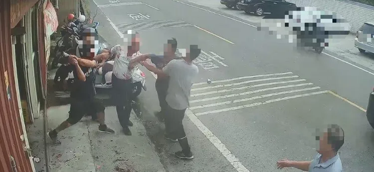 黃姓小吃店老闆持球棒與蘇男一行三人在馬路上打架。讀者提供