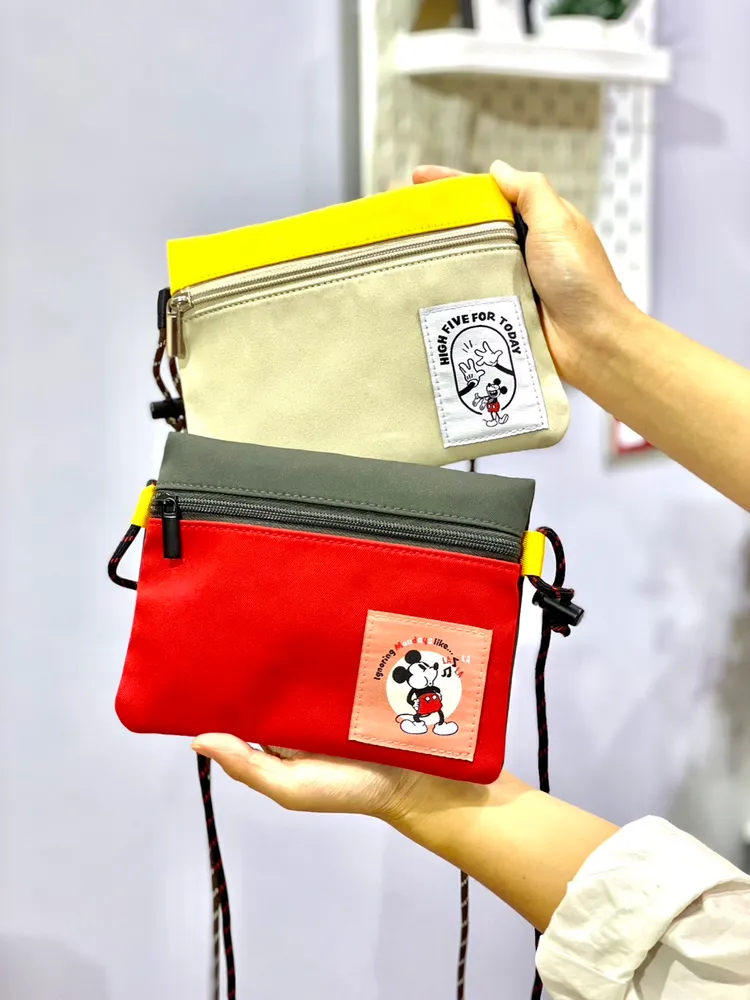 萬用小卡包共有紅黃兩種配色，可放手機、錢包、鑰匙等隨身物品，小而不廢很好裝，可依個人需求調節背帶長度，5點+99元即可擁有。曾仲葳攝