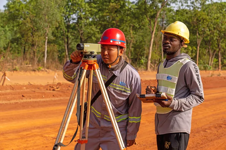 中國企業在象牙海岸興建公路，一名中國測量員上月30日正教授學徒測量技巧。新華社
