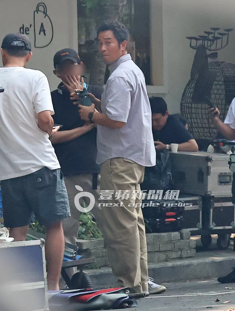 補充水分完的張孝全（中）不時左顧右盼，與工作人員聊得十分起勁。特勤中心攝