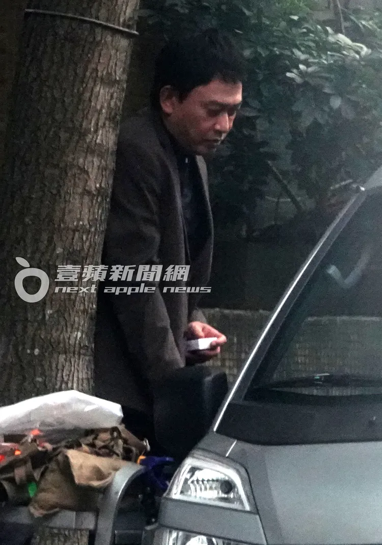 王識賢走到一旁休息，手上依舊拿著菸盒。特勤中心攝