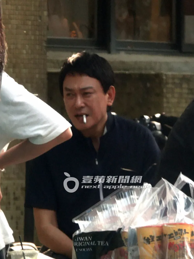 王識賢坐在一旁，無聊到抽起香菸消磨時間。特勤中心攝、《壹蘋》提醒您，吸菸有礙身體健康