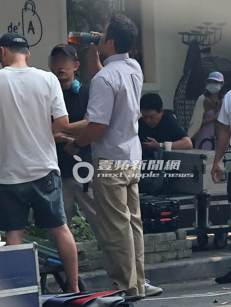 天氣炎熱，張孝全（中）仰頭喝著水壺解渴。特勤中心攝