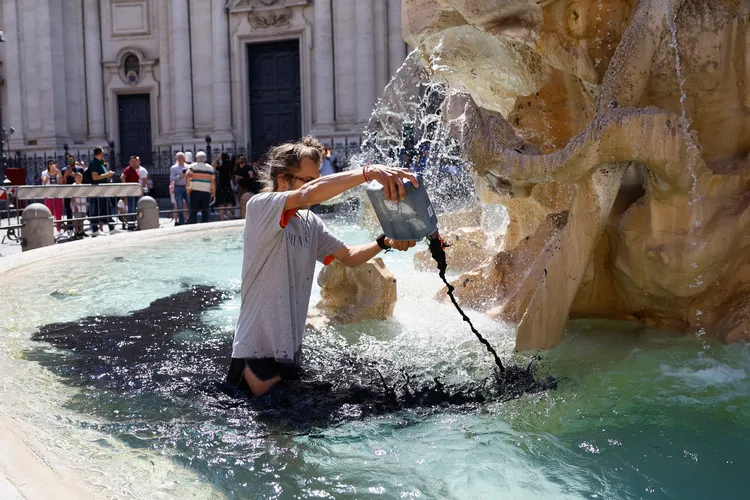 示威者把黑水倒入池中。美聯社